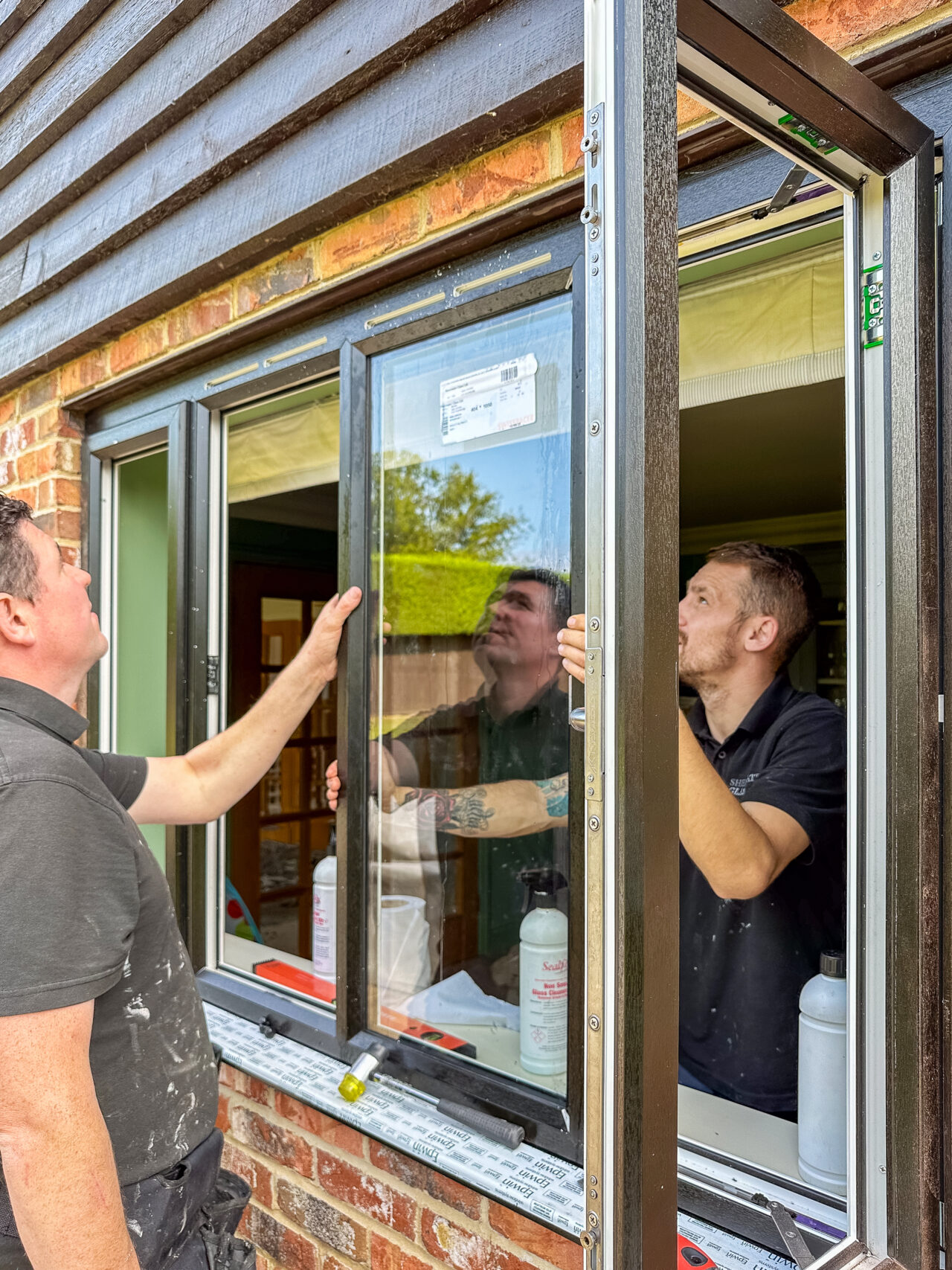 Fitters Installing Black uPVC Slimline windows
